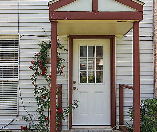 Covered entry with beautiful landscaping.