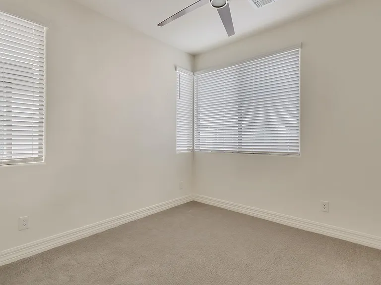 Second bedroom is a nice size for a guest or family member and has same fan and window treatments as other areas in the house.