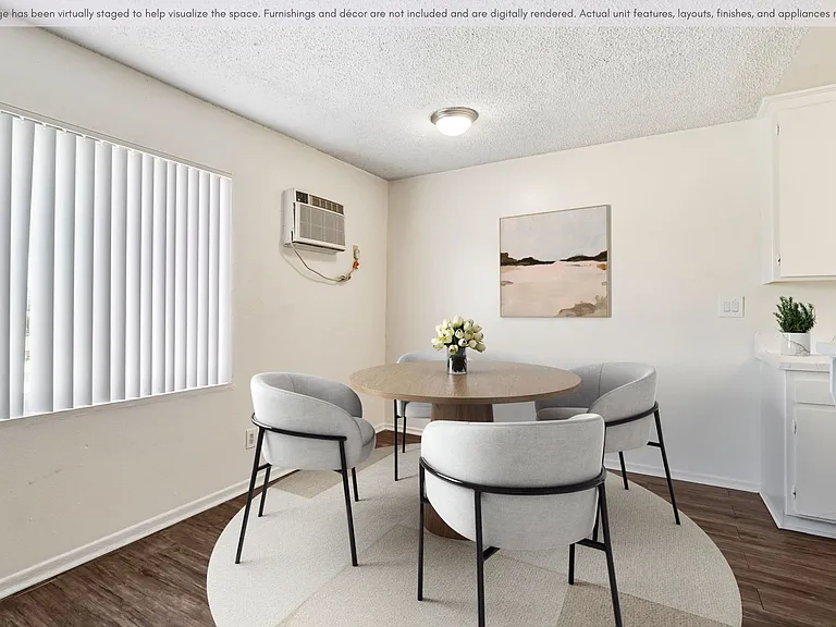 Large dining area situated next to large window and AC unit.