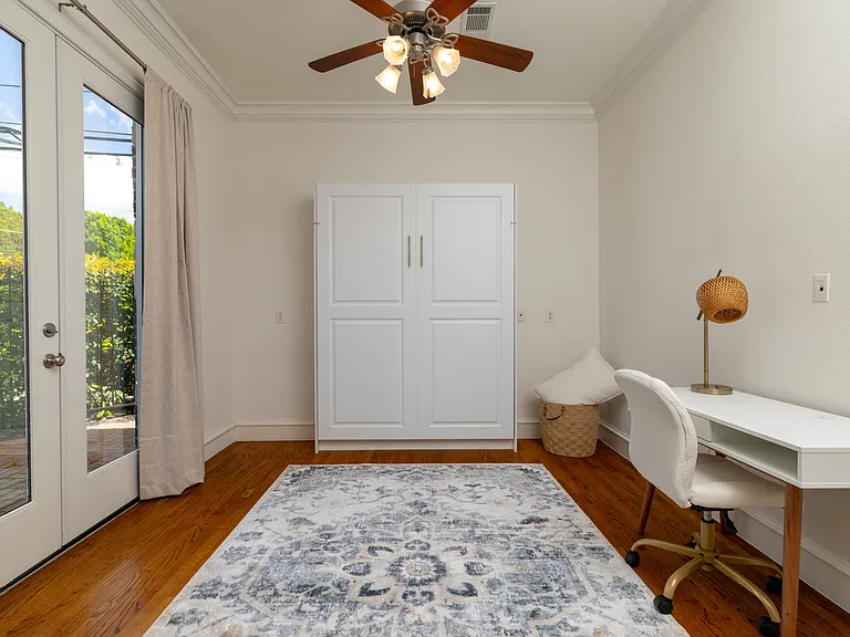 Bright workspace with a desk, Murphy bed, and patio access