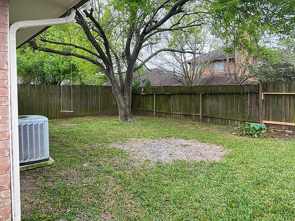 Backyard has a tree for shade in the summer.