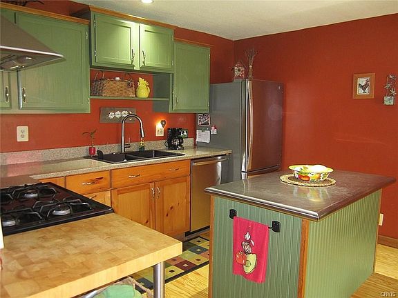 The spacious Country Kitchen boasts staggered top cabinets w/natural wood crowns, Black Onyx double sink with goose-neck faucet, refinished yellow-pine hardwoods, Silestone countertops, and stainless steel appliances.