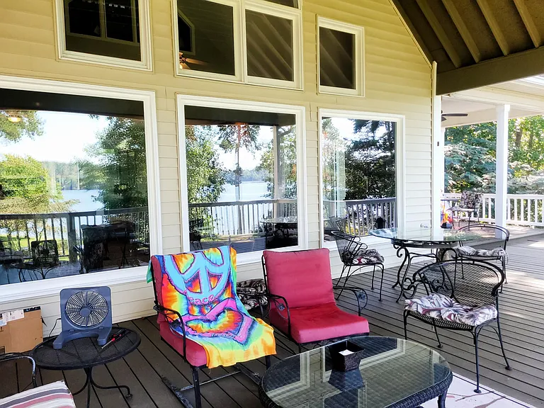Part of deck outside picture windows. Lake shows in window reflection.