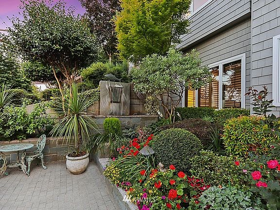 Tranquil fountain, slate landscape wall, and colorful gardens greet you at the front doorl.