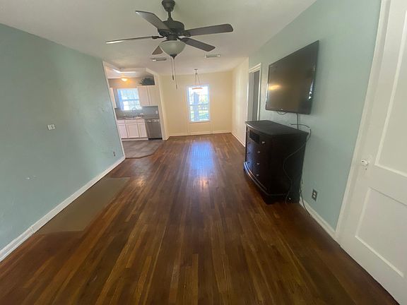 Large spacious living room open to dining room and kitchen. Credenza in picture has been removed, but TV stays.