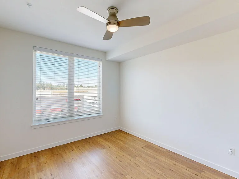 Spacious apartment Bedroom with Wood-Style Flooring.