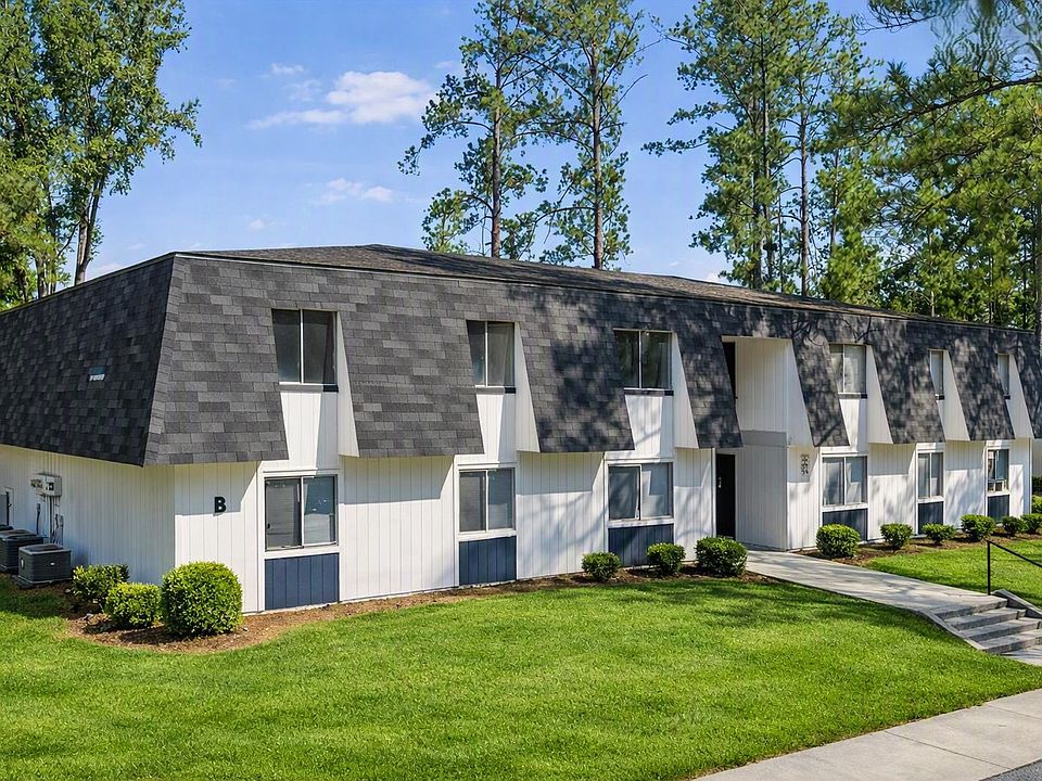 Richmond Hills Apartments showcases a charming exterior nestled among lush greenery and modern architecture. Enjoy a comfortable lifestyle with spacious units and inviting surroundings. Explore your new home today!