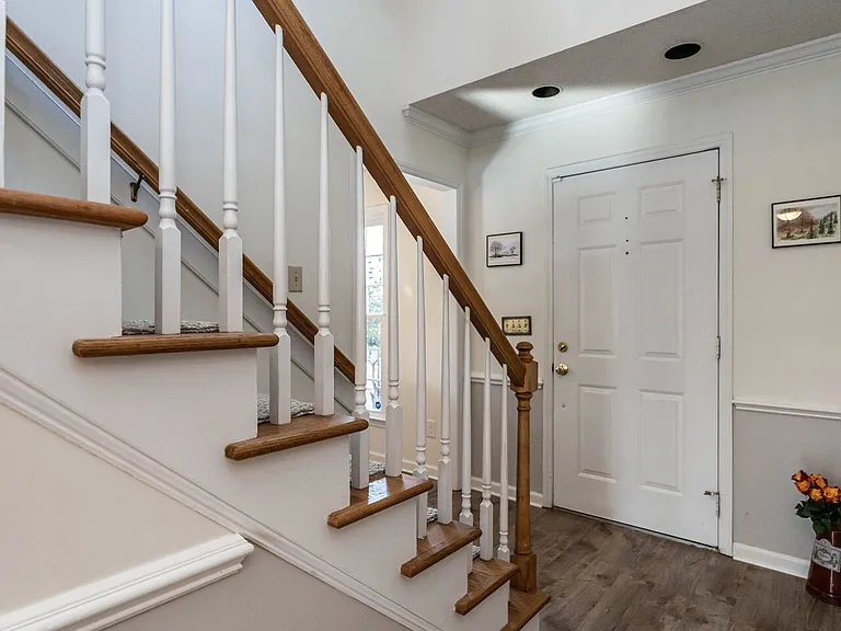 Coming down the hall from the kitchen or the half bath toward the front door.