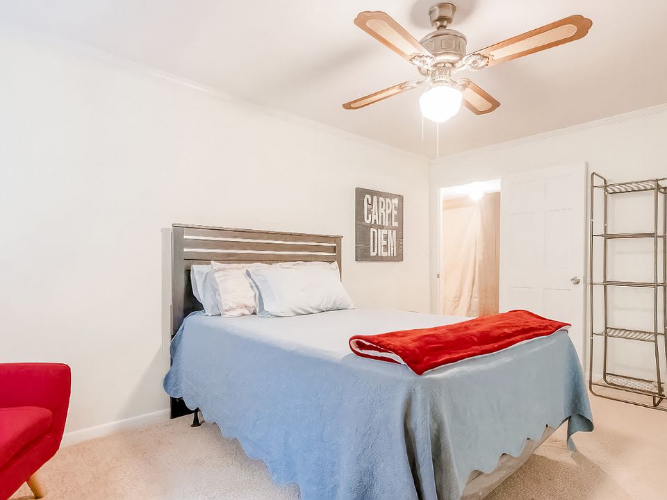 Queen bed, dressor /mirror, and open clothes rack, chair and nice tile floor