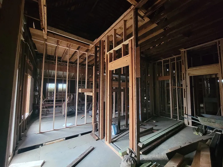 Picture from 2025. Standing in dining room, looking southwest with the office in the foreground, kitchen to the right, bathroom in the mid right and living room to the far left. When we say this is a serious rehab, we mean it.