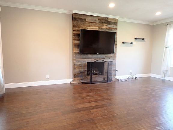Step down living room with wood flooring, recessed lighting, custom fireplace