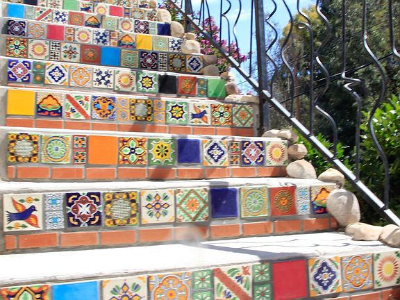 Artisanal hand glazed tiles lead up to the front door