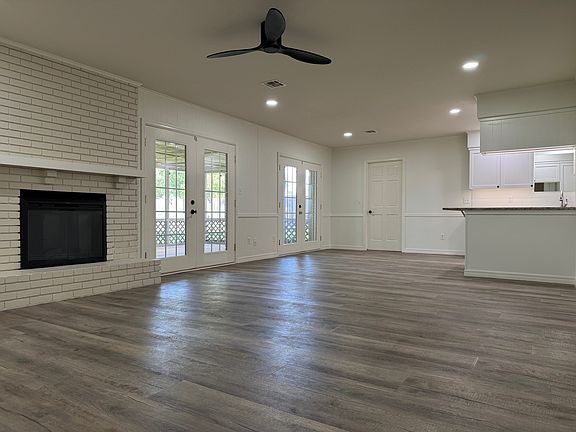 living area with ceiling fan and fireplace (with remote controls); french doors lead to fully screened in patio