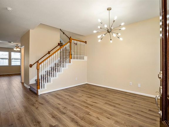 Newly installed wood-like laminate flooring lead into the living areas of the home.