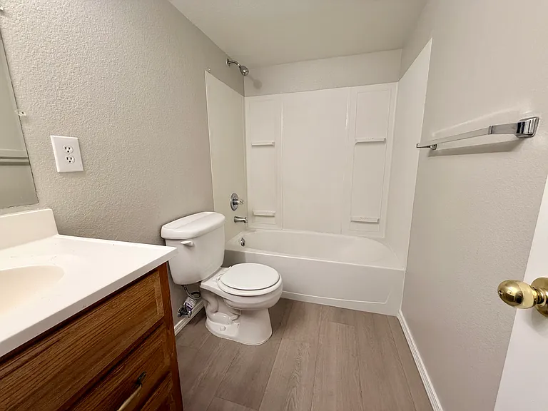 Updated full basement bathroom featuring new luxury vinyl plank flooring, tub/shower combination, and convenient access from the family room and third bedroom.