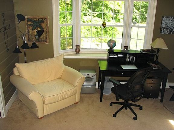 Cozy den with bay window and built in book cases, has adjacent laundry/storae room, and opens to the back deck and on to the sunny fenced yard