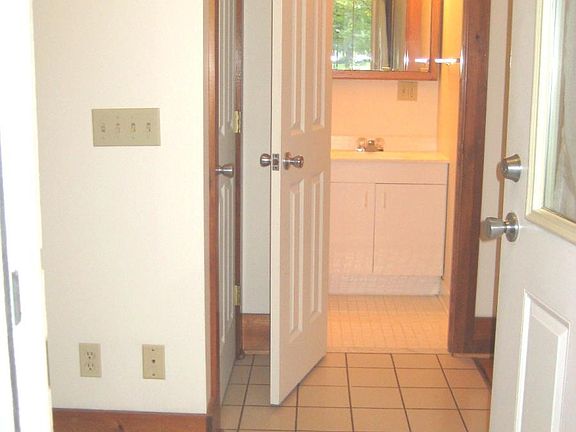 tiled entrance with view of 1/2 bath
