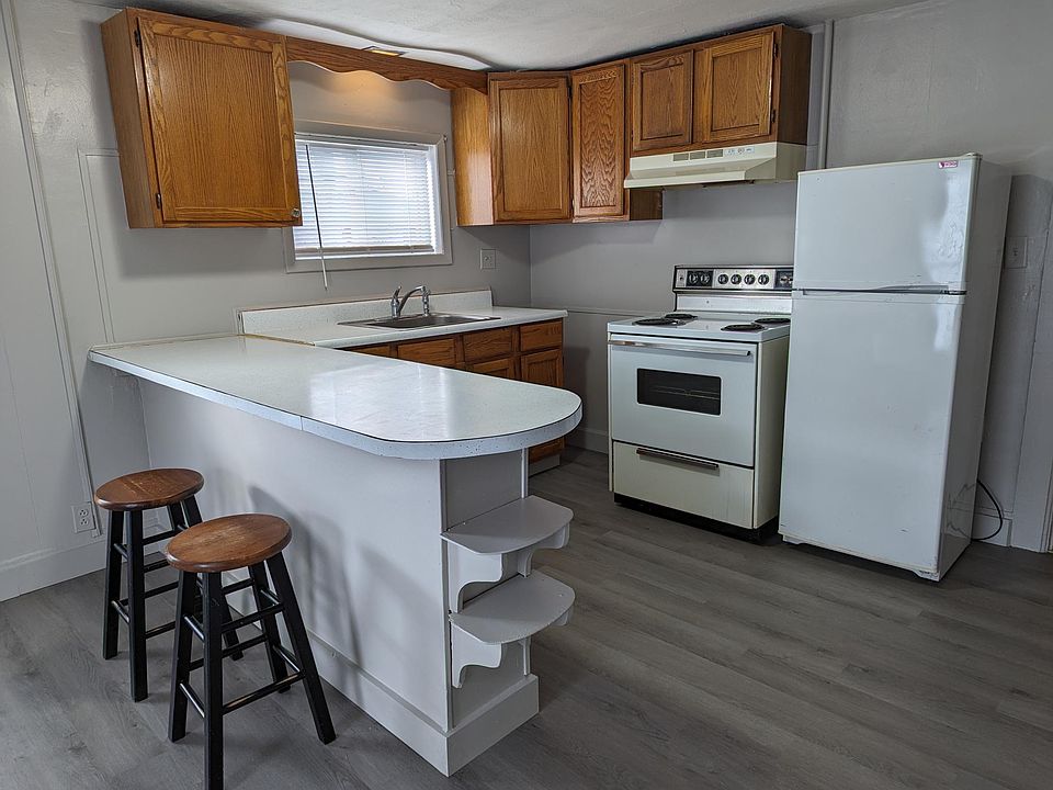 Kitchen with window above sink, electric stove with vent, peninsula with space