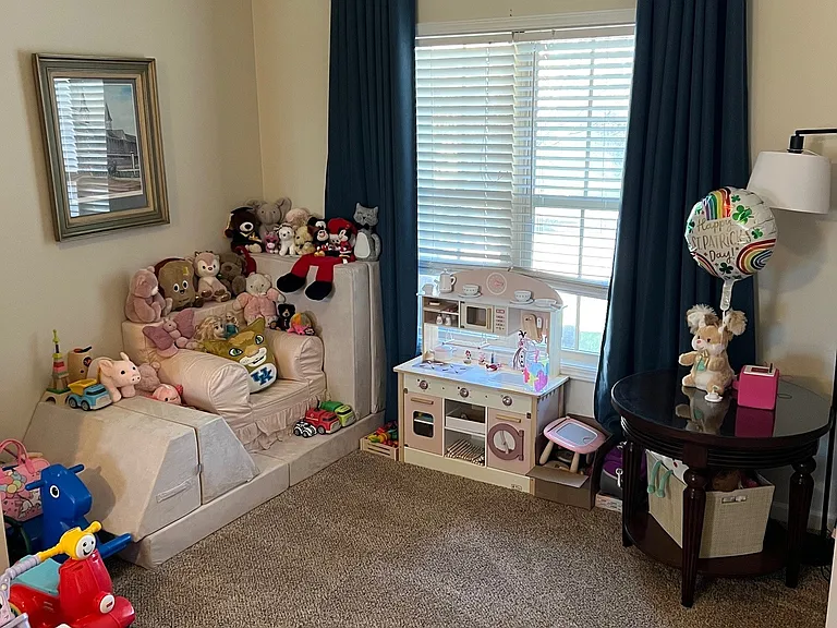 Living room area perfect for extra seating or toy storage for the little ones.