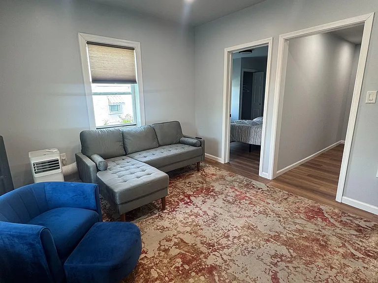 Living area with durable wood-style floors, recessed lighting, and seating space, plus easy access to adjoining rooms.