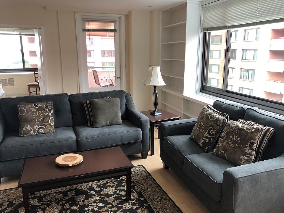 Living room window, built-in shelving, entrance to balcony, and door to bedroom