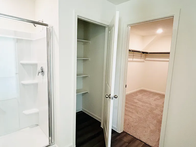 Primary bathroom with linen closet and walk in closet