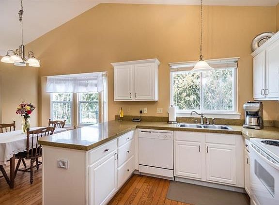 Sunny kitchen w granite counters, bay window, and eat-in area