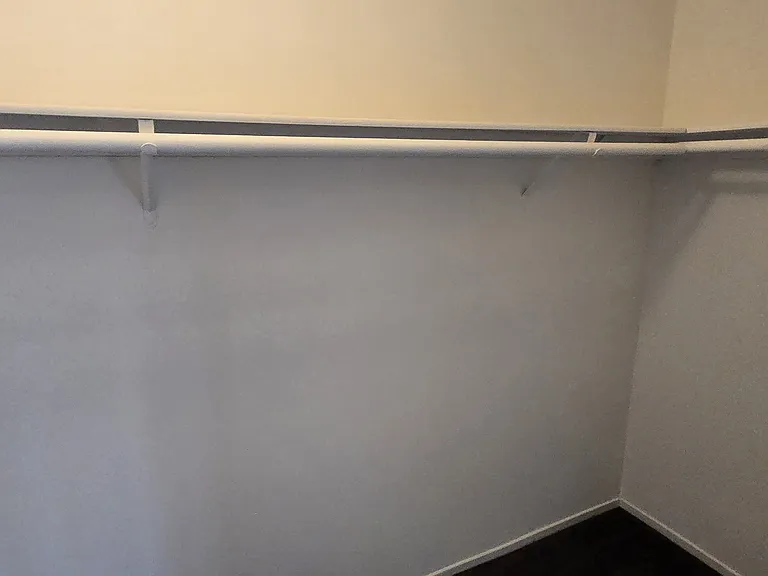 Walk-in closet with wrap around shelving and hanger rods