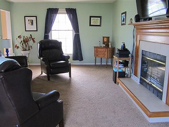 The front-to-back Greatroom is warmed by a raised hearth fireplace with an oak mantle and boasts new plush carpeting.