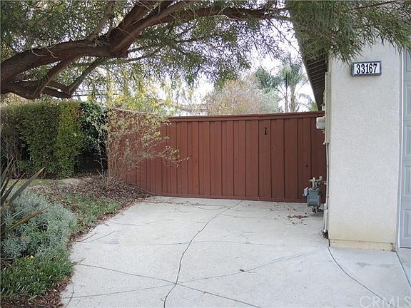 Extended driveway with wide drive thru gate along the side of the 3 car garage.