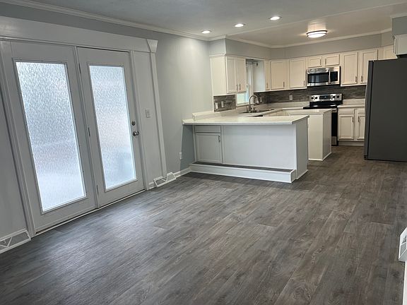 Kitchen extends into den with patio door to a large entertaining deck.
