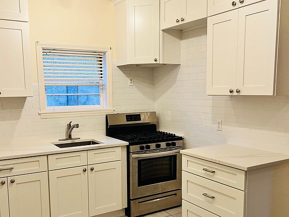 Renovated Kitchen with new cabinets, backsplash, and counters and sink. Stainless steel appliances.