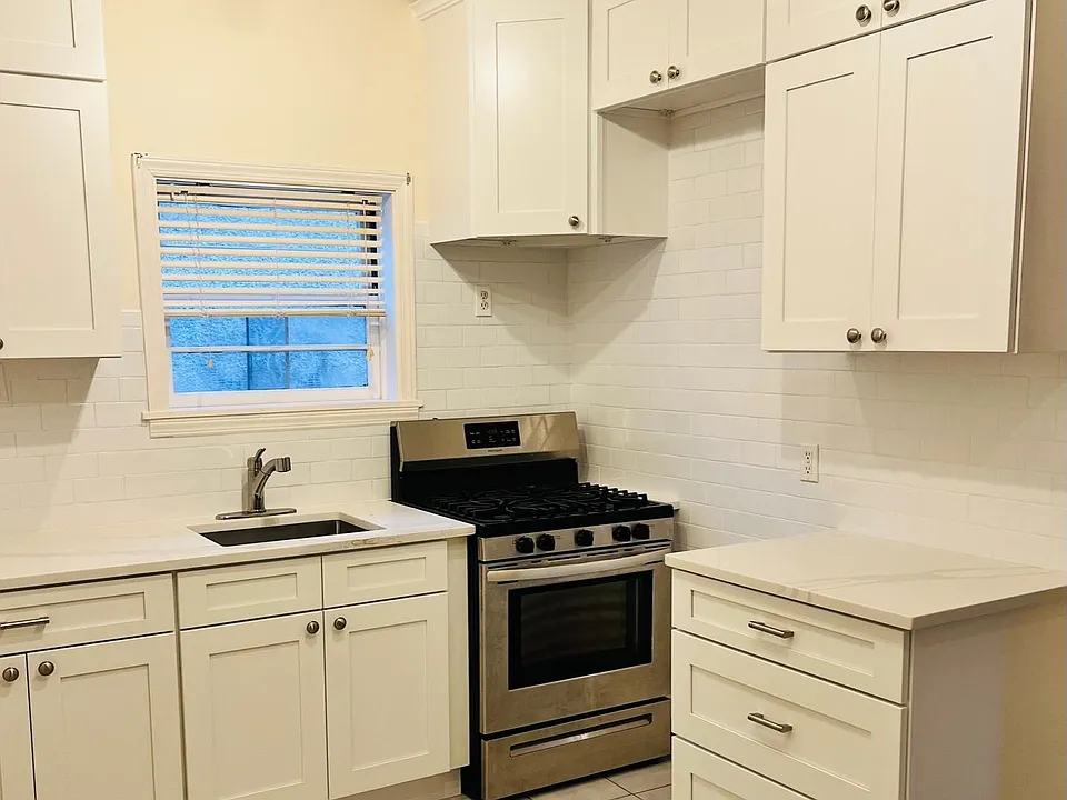 Renovated Kitchen with new cabinets, backsplash, and counters and sink. Stainless steel appliances.