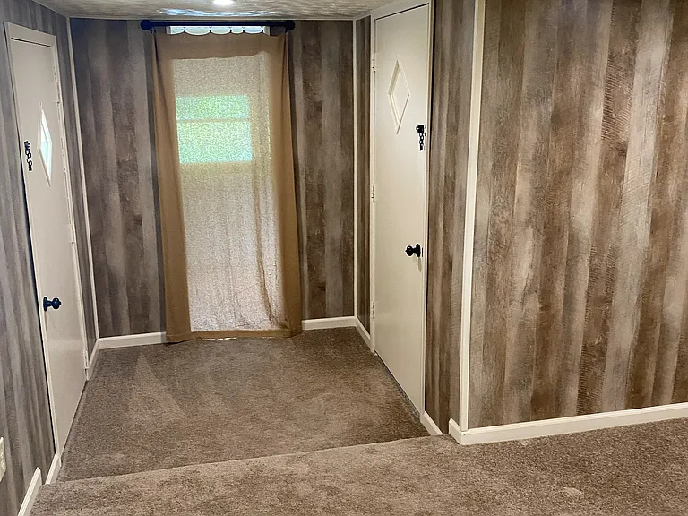 (2 of 6) Master bedroom with entry into the storage/work shop area that leads outdoors.