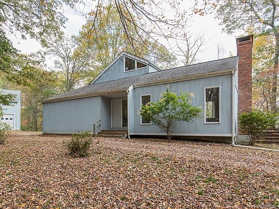 View of front door and detached garage with loft.