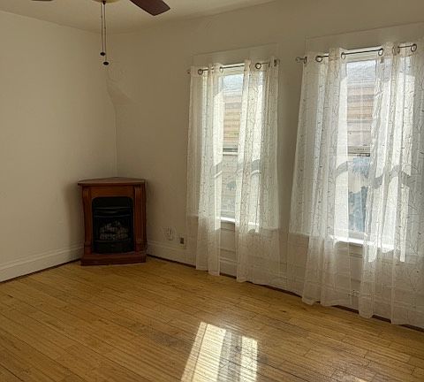 Living room with fireplace, tall ceilings and wood floors.