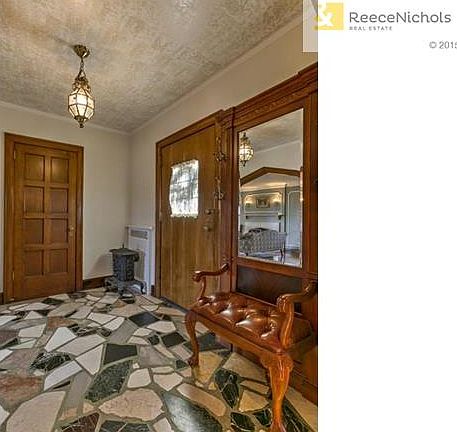 Original marble flooring, chandelier and walnut woodwork grace the entry.