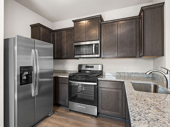 The kitchen has beautiful brown cabinetry.