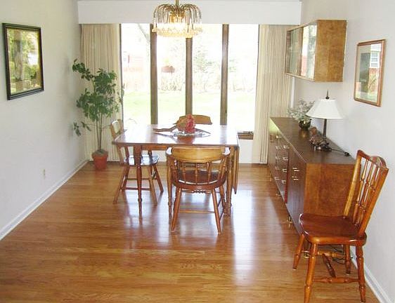 The living room extends directly to the dining room, also with newer wood flooring, and relaxing views of the back yard through the large windows.