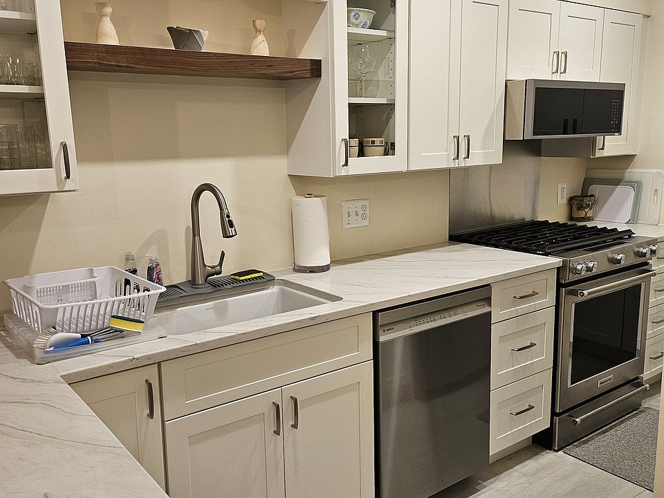 Newly renovated kitchen includes appliances, pots, pans, and dishes