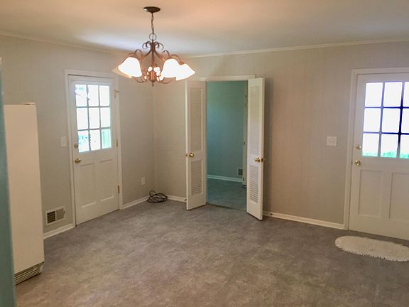 BREAKFAST ROOM, WITH NEW FLOOR, DOORWAY TO LARGE LAUNDRY ROOM, DOORS TO CARPORT AND BACKYARD.