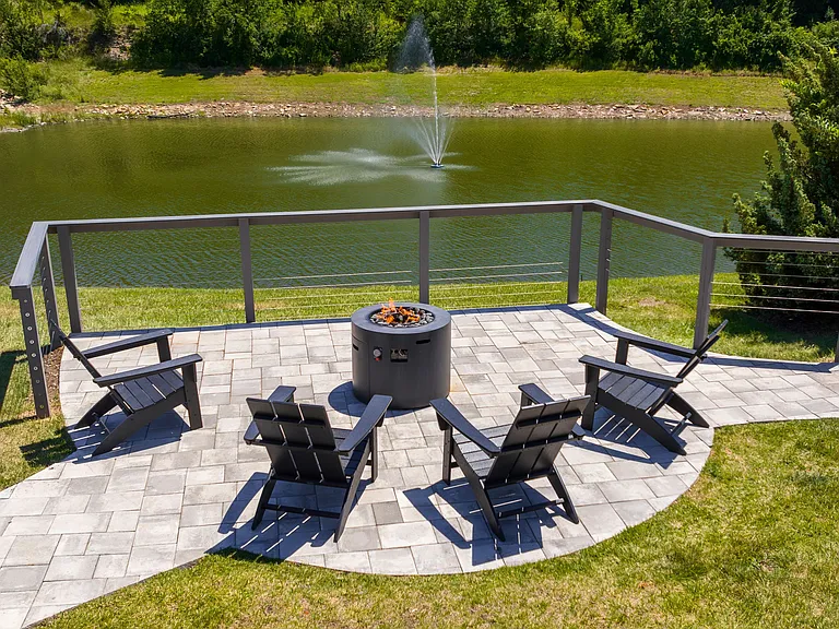 Relax by the fire pit with stunning views of the pond and fountain. Enjoy peaceful evenings with friends in this serene setting.