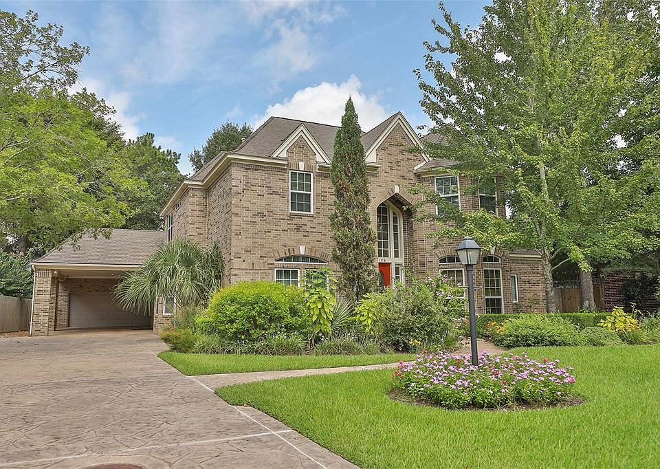Upgraded stamped concrete drive way leads to 2 car porte cochere and oversized detached garage