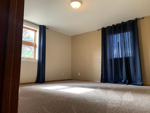 1st spacious bedroom on the main floor. Updates done in 2022: New carpet, paint, light fixture, and curtains.