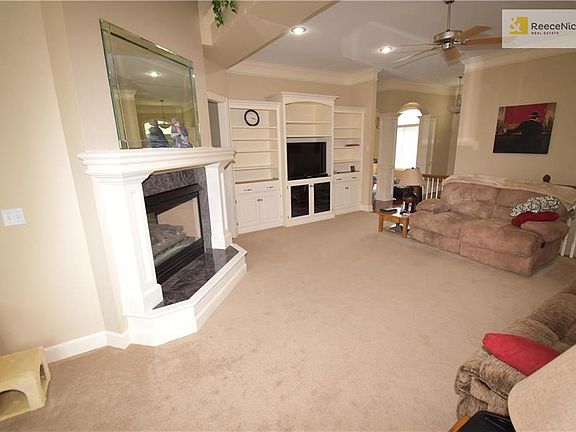 Great Room with see thru Fireplace to Hearth Room.  Note: the expensive Built In Entertainment Center in back, nice cabinets below, plenty of upper shelves, note the very tall Crown Moulding, thorough-out most of Main Level
