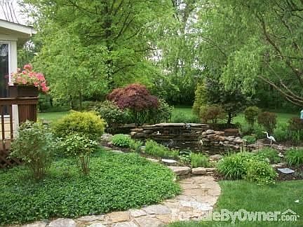 Landscaped pond with lighted waterfall.
						:
						Professional landscape lighting, bridge over simulated dry creek bed.