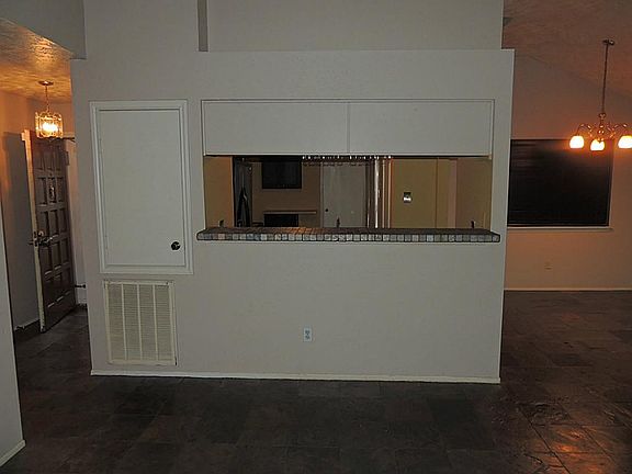 View from den into kitchen with slate counter tops