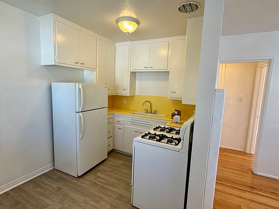 Kitchen with refrigerator and gas stove.