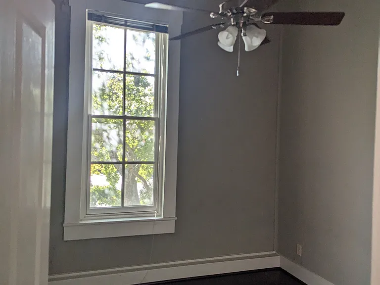 2nd bedroom with 2 small closets. Overlooks garden and trees.