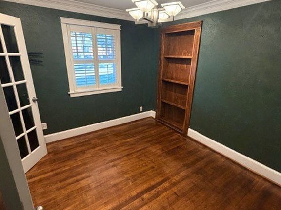 Sitting room / home office with built-in bookshelf door leading to a private 4th bedroom/flex space_perfect for guests, a quiet workspace, or a bonus retreat.